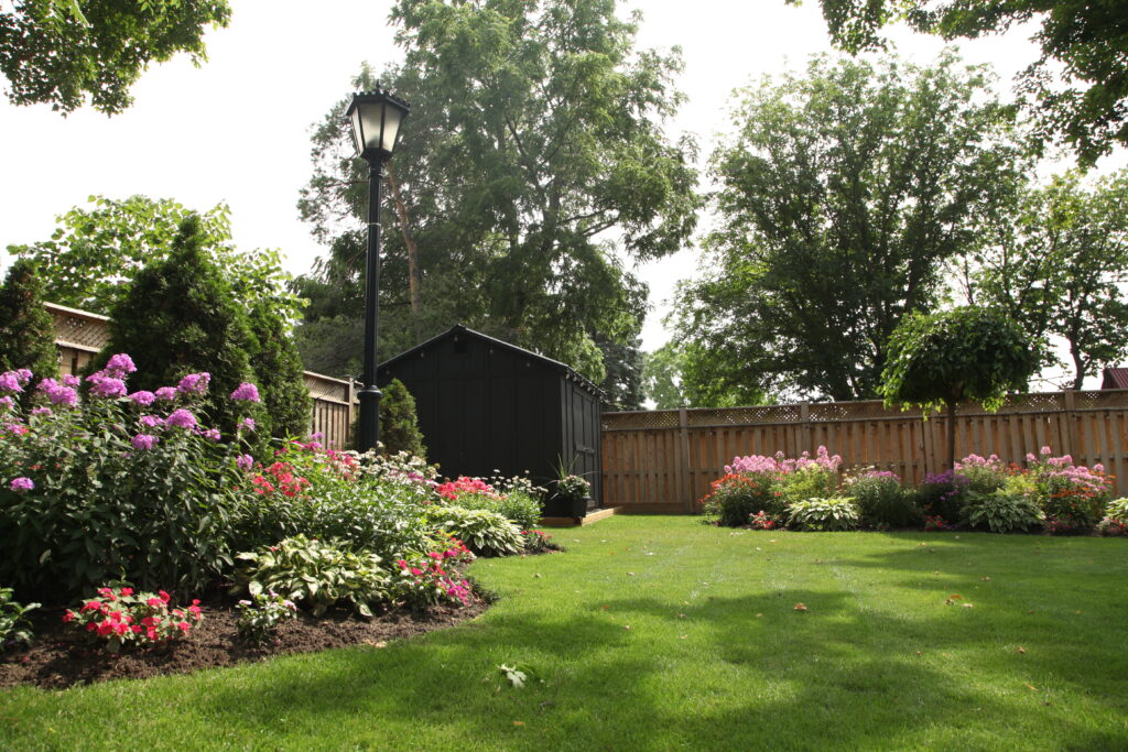 Outdoor shed in a backyard setting with garden and lawn