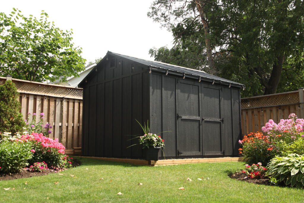 Close-up of a grey backyard shed with board-and-batten siding, windows and black trim – Glenco Sheds example