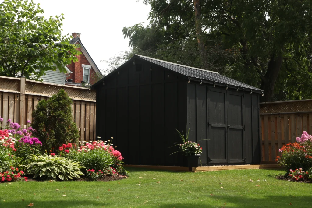 Close-up of a grey backyard shed with board-and-batten siding, windows and black trim – Glenco Sheds example